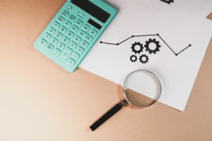 Análise fiscal e financeira com calculadora, lupa e gráficos utilizados na gestão e planeamento empresarial.