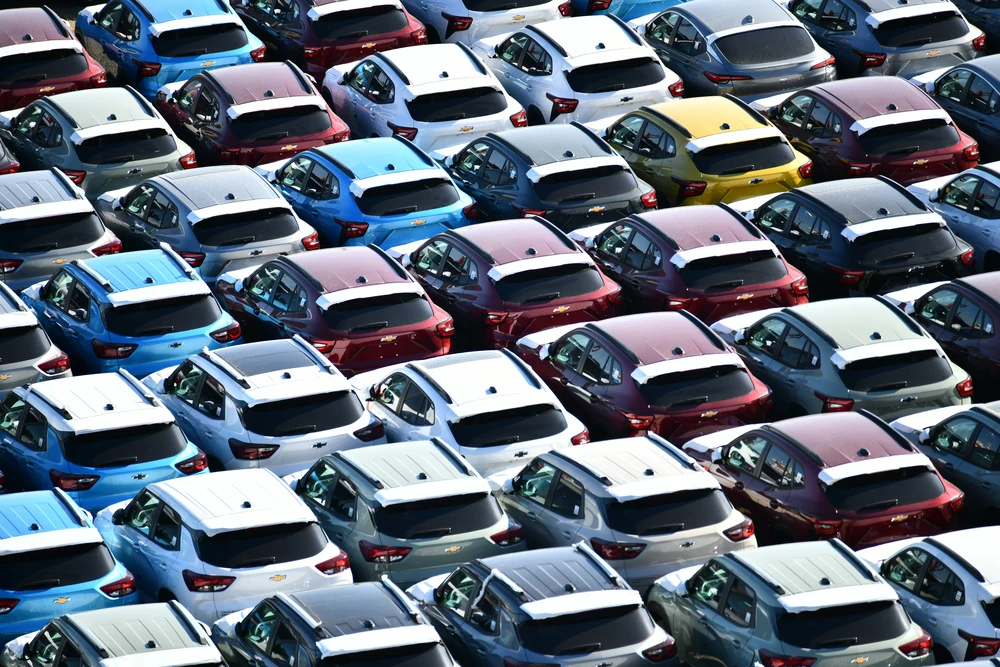 Parque com várias viaturas novas organizadas num stand automóvel.